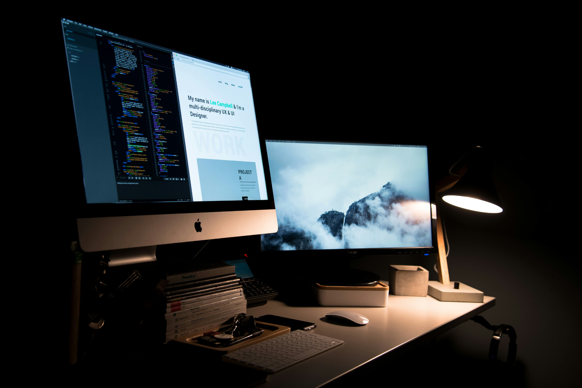 Postazione di lavoro con monitor che mostrano codice e interfaccia UI in ambiente dark