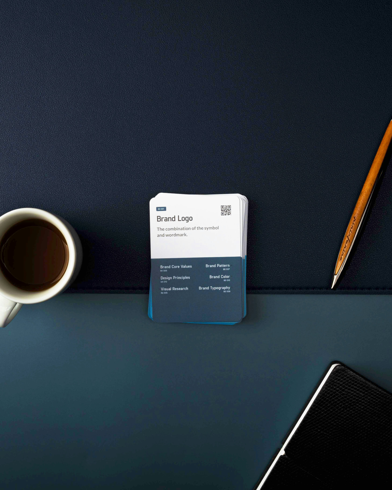 Scrivania scura con taccuino di brand identity, caffè e penna